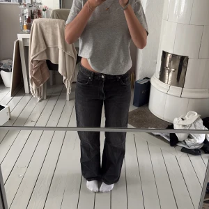 Svarta raka jeans från Zara - Säljer ett par svarta jeans från Zara i storlek 34. Jeansen har rak passform, klassisk femficksdesign och normal midja. Materialet är denim i bomull och de har en snygg, lite tvättad svart färg. Perfekta till sneakers eller boots. Midjemått: 38cm, Grenlängd: 27cm, innerbenslängd: 72cm. Skulle passa någon som är 163cm eller kortare!. Har använt jeansen en gång. 