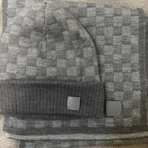 Grå halsduk och mössa från Louis Vuitton - Grå LV mössa och halsduk i riktigt bra skick. Har använt den bara under en vinter. Möts i Stockholm 