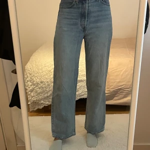 Levi's 501 ljusblå raka jeans - Säljer ett par klassiska Levi's 501 jeans i ljusblå tvätt. Jeansen har hög midja, raka ben och är tillverkade i robust denim. Perfekta för dig som gillar en tidlös och avslappnad look. Levi's patch och röd etikett bak.