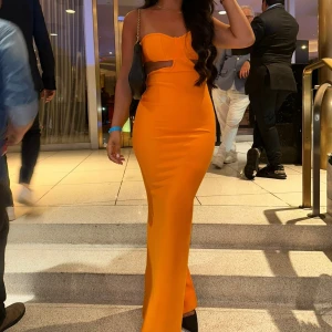 Orange långklänning med cut out - Säljer en superfin orange långklänning med figurnära passform och snygg cut out-detalj under bysten. Använd 1 kväll. St Small. Pris 300 kr