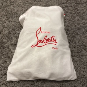 Mörkblå sneakers från Christian Louboutin - Snygga mörkblå sneakers från Christian Louboutin i mocka med svarta snören och diskret logga bak på hälen. Skorna har rund tå, platt sula och lyxig känsla med beige innersula. Kommer med originalpåse och äkthetskort.