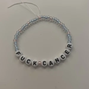 Hand gjorda pärlarmband med texten Fuck Cancer - Ett handgjort armband med ljusblå och ljusrosa pärlor samt vita bokstavspärlor som bildar texten 'FUCK CANCER'.  Färger går att välja själv och även om man vill ha med hjärtan pärlor på eller inte! Dessa säljer jag för 100kr styck då 60% går till valfri cancerfond! Och resterande 40% går till att köpa nytt matrial:) perfekt för att kunna stötta cancerfonden och få något fint också!  (Snörena på armbandet klipps av innan de säljs)❤️