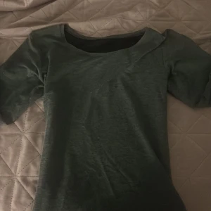 Mörkgrå Långarmad - En enkel och stilren mörkgrön topp med rund halsringning och halvärm. Toppens material känns mjukt och lätt, perfekt för en chill look. Passformen är normal och toppen är enfärgad utan några extra detaljer.