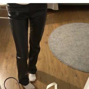 Lågmidjade skinnbyxor - Snygga svarta bikbok byxor i skinnimitation med raka ben. Lågmidjade i storlek 36. Knappt använda. Nypris 600kr