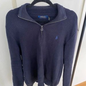 Mörkblå Halv Zip från Ralph Lauren - Mörkblå stickad tröja från Polo Ralph Lauren med halv dragkedja och klassisk krage. Den är perfekt nu till hösten och vintern. Den passar dig runt 175. Hör gärna av dig vid minsta fundering 🙌🙌
