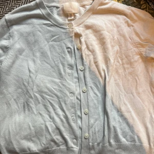 Vit kofta från H&M - Säljer en söt kofta från H&M i vit. Koftan har rund halsringning, långa ärmar och knappar framtill. Perfekt för lager-på-lager och chill vårstil.