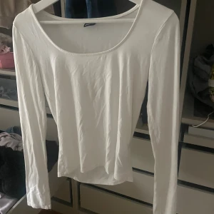 Vit långärmad topp från Gina Tricot - En basic vit långärmad topp från Gina Tricot i storlek S. Toppen har rundad, bred urringning och är figurnära i modellen. Perfekt att styla med jeans eller kjol för en clean look. Tillverkad i mjukt och stretchigt material för extra komfort❣️❣️❣️
