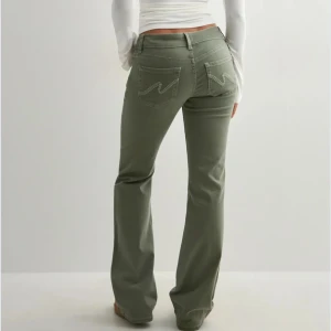 Gröna bootcut jeans med broderade fickor - Snygga gröna jeans från Nelly med bootcut passform. I bra skick. Ny pris 700 kr