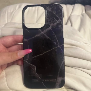 Skal iPhone 14 Pro Max - Svart marmorskal från ideal of sweden till iPhone 14 Pro Max, i använt skick men fint skick, inga defekter 