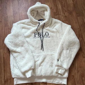 Vit fleece hoodie från Polo Ralph Lauren - Säljer nu min Ralph lauren hoodie i fleece material som är perfekt för hösten/vintern. Endast använd ett par fåtal gånger så den är i nyskick! Väldigt sällsynt då den är slutsåld på många ställen, Vid frågor skicka gärna ett dm och pris kan diskuteras!!!