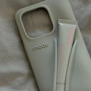 Rhode iPhone Case med Lip Treatment Holder - Stilren Rhode mobilskal för iPhone med integrerad hållare för läppbalsam.  För 14 PRO men passar även i storlek 15 PRO som jag har