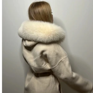 Beige kappa med fluffig huva och bälte - Pälskappa från RoyalFur. Använd typ 2 gånger så i fint skick, inga fläckar och pälsen är fin. Nypris är 2600kr. Det är Ullmix i materialet. Den är varm och superfin. Storlek S. 