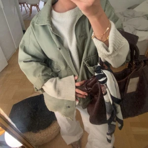 Oversized grön jeansjacka  - Snygg oversized ljusgrön overshirt i bomull med klassisk krage och knappar framtill. Jackan har en avslappnad passform och råa kanter nertill för en cool vibe. Perfekt att slänga över en hoodie eller stickad tröja för en chill look.