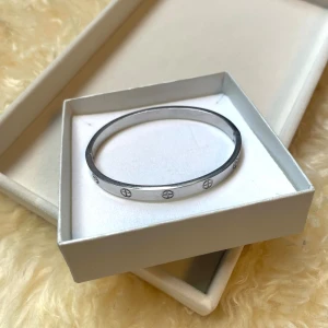 Silverfärgat armband med gravyr - Stilrent armband i silverfärg med rund form och ingraverade skruvliknande detaljer runt om. Armbandet är i rostfritt stål och har en minimalistisk design som passar till många olika stilar. Perfekt accessoar för dig som gillar enkla men snygga smycken.