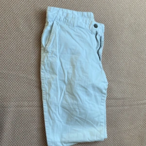 Vita chinos från Koton, storlek 34/32 - Snygga vita chinos från Koton i storlek 34/32. Byxorna har klassisk passform med fickor fram och bak, bälteshällor och stängs med knapp och dragkedja. Perfekta för en fräsch och stilren look. Tillverkade i bomull för en skön känsla. Oanvända  !
