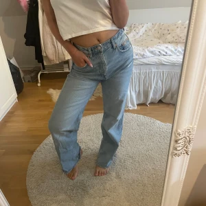 Ljusblå raka jeans  - Säljer ett par ljusblå jeans med klassisk femficksdesign och raka ben. Jeansen har hög midja och är tillverkade i robust denim. Perfekta för en avslappnad och trendig look.