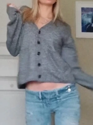 Grå stickad kofta - Säljer en grå stickad kofta med svarta knappar framtill. Den är från hm i storlek xs och använd fåtal gånger.  Pris kan diskuteras 💕
