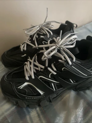Balenciaga Track sneakers svart/vit - Säljer ett par Balenciaga Track sneakers i svart med vita detaljer och vita snören. Skorna har en chunky sula, meshpaneler och flera lager av syntetmaterial för en futuristisk look. Balenciaga-logga på sidan. Perfekta för dig som gillar statement sneakers.