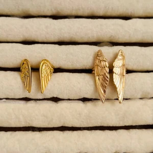 Guldiga ringer med vinge-design - Två ringar i form av vingar i guldfärgad metall. Ena paret är mindre med detaljerade mönster, det andra paret är större och har en mer markerad fjäderstruktur. Perfekta för dig som gillar unika och trendiga accessoarer.( styck pris)