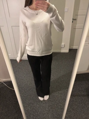 Vit stickad tröja från Vila - Säljer en enkel och stilren vit stickad tröja från Vila. Tröjan har rund halsringning, långa ärmar och ribbade muddar vid ärmslut och nederkant. Perfekt basplagg att matcha till olika outfits.