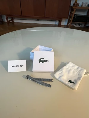 Lacoste armband - Mycket snyggt länk armband från Lacoste.  Helt nytt och aldrig använt. Går att ta av och på länkar. Skickar inom 48 timmar. Hör av dig vid frågor.