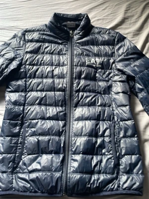 Mörkblå dunjacka från EA7 Emporio Armani - Snygg mörkblå dunjacka från EA7 Emporio jackan lite syd med sy tråd men annars är jackan bra den är inte så varm använd 5 gånger 