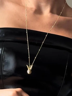 Guldigt halsband med kaninberlock  - Snyggt halsband i guldfärg med en detaljerad kaninberlock. Kedjan har små kulor längs hela längden som ger extra stil. Perfekt accessoar för dig som vill sticka ut med något lekfullt och trendigt. Passar till många olika outfits.