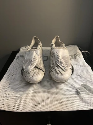 Adidas Predator fotbollsskor vita - Snygga vita Adidas Predator fotbollsskor med snörning och täckande plös. Skorna har en modern design med silvriga detaljer och mönstrad ovansida. Använd några gånger( pris kan diskuteras)