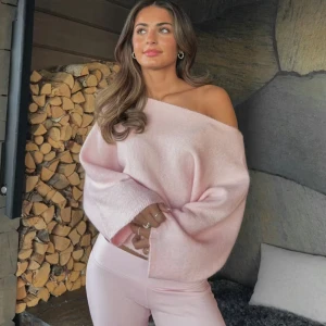 Ljusrosa off shoulder stickad tröja - Trendig ljusrosa stickad tröja med bred off shoulder-ringning och vida ärmar. Mjuk och fluffig känsla, perfekt för en avslappnad och stilren look. Passar snyggt till både jeans och mjukisbyxor🫶🏻