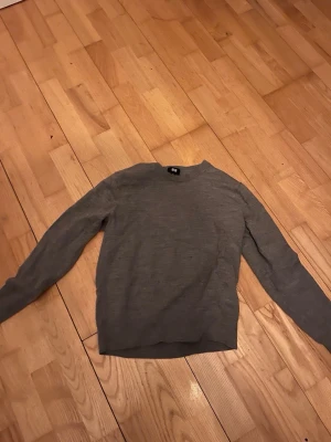Grå stickad tröja från Uniqlo - Säljer denna stickade tröja  Klassisk modell som funkar till det mesta.