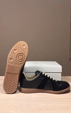 Maison margiela GATs Svarta - Svarta GATs från Maison Margiela i helt nyskick. Skorna är i den klassiska svarta färgen med brunt under. Passar vinter som sommar till de allra flesta outfitsen. Storlek 44.