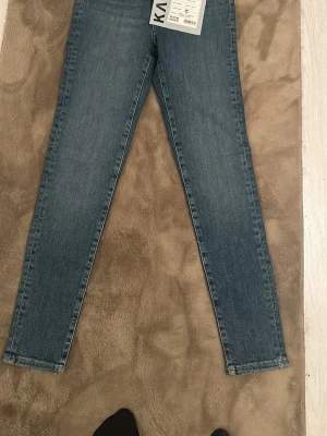 Blå skinny jeans  - Snygga blå skinny jeans med klassisk femficksdesign och smal passform. Jeansen har normal midja och är tillverkade i stretchigt denimtyg för en bekväm känsla. Perfekta att matcha med en hoodie eller t-shirt.