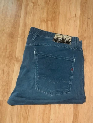 Replay Anbass jeans  - Snygga blåa Replay Anbass Jeans i slim fit. Midja 49cm, längd 105cm. Obs jeansens söm på bakfickan har lossnat lite. JAG SKICKAR EJ FLER BILDER NÄR JAG BÄR JEANSEN! för bättre inblick i passformen rekommenderar jag att googla på modellnamnet. För storleksguide kolla måtten noggrant då jeansen alltid kan vara uppsydda heller krympta och jag ej tar emot returer :) s6,3