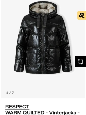 Svart pufferjacka från Respect - Snygg svart pufferjacka från Respect med glansig finish, stor huva och breda snören. Jackan har två stora fickor framtill och dragkedja. Perfekt för kalla vinterdagar och riktigt trendig look. Jättevarm och super bekväm, använd max 5 gånger nypris 1100kr