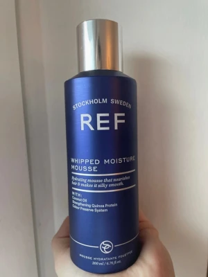 REF Whipped Moisture Mousse 200ml - Helt oöppnad, köpt för 315 kr.                              REF Whipped Moisture Mousse är en återfuktande hårmousse i en snygg mörkblå flaska med silverlock. Innehåller kokosolja och quinoa protein som ger näring och gör håret silkeslent. Perfekt för dig som vill ha ett mjukt och återfuktat hår.