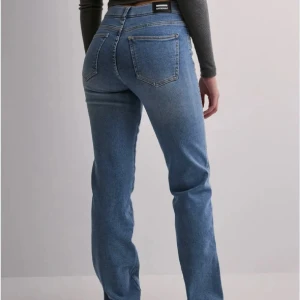 Blå raka jeans från Gina Tricot - Snygga blå jeans från Gina Tricot med klassisk femficksdesign och raka ben. Jeansen har hög midja och är tillverkade i mjukt denimtyg som ger en skön passform. Perfekta för dig som gillar en tidlös och clean look.