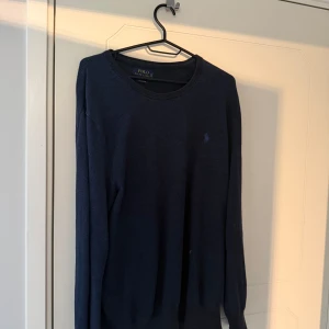 Mörkblå stickad tröja från Polo Ralph Lauren - Mörkblå stickad tröja från Polo Ralph Lauren, säljer den eftersom den inte kommer till användning, nypris cirka 2000 mitt pris 700kr, väldigt skön och varm tröja nu inför vintern 