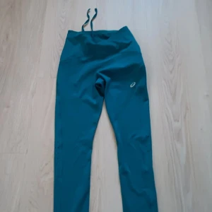 Gröna asics tränings byxor  - Gröna asics byxor i träningsmaterial har aldrig använt och har prislappen kvar på, original pris är 749 kr men säljer för 600 kan diskutera priset
