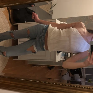 Vit ribbad oneshoulder topp från H&M - Säljer en snygg vit ribbad topp från H&M i storlek S. Modellen är oneshoulder och sitter tight mot kroppen. Perfekt för dig som gillar stilrena och trendiga plagg. Materialet är mjukt och stretchigt, vilket gör den superbekväm att bära.