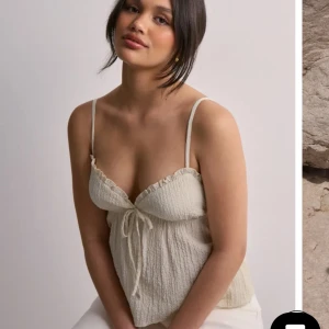 Beige topp med knyt och volang - Söt beige sommartopp köpt på Nelly i stl XS, använd fåtal gånger! 