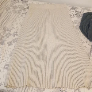 Beige ribbad långkjol från Lindex - Säljer en beige långkjol från Lindex i ribbat material. Kjolen har en mjuk och stretchig känsla, med snygga vertikala ränder som ger en stilren look. Perfekt för dig som gillar en enkel men trendig stil.