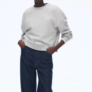 Grå  sweatshirt i bomull - Enkel och stilren ljusgrå sweatshirt i oversized modell. Tröjan har rund halsringning, långa ärmar och är tillverkad i mjuk bomull. Perfekt för en avslappnad och trendig look.