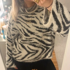  Polotröja - Säljer en fluffig och mysig polotröja från H&M i storlek S. Tröjan har ett svartvitt zebramönster, hög polokrage och är stickad i ett mjukt material. Säljer då ja inte gillar så höga kragar, priset går att diskuteras💕