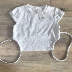 Grå topp med rosett bak! 🎀 - Fin grå topp som sitter spänt, och med en rosett man kan knyta bak vid ryggen!