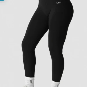Svarta seamless tights från ICANIWILL - Svarta seamless tights från ICANIWILL med hög midja och tight passform. Snygg minimalistisk design med diskret logga framtill. Perfekta för träning eller chill, tillverkade i stretchigt syntetmaterial som sitter skönt hela dagen. Endast testad, ej använd. 