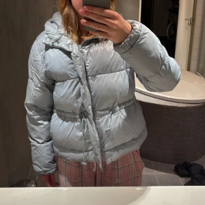 Ljusblå jacka - Köpt på Gina för 700kr, knappt använd, kan välja själv hur den ska sitta vid midjan, kortare variant, storlek xs men sitter som S. Väldigt tjock och varm