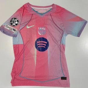 Barcelona Raphinha 11 Nike rosa matchtröja - Säljer en FC Barcelona fotbollströja från Nike i rosa och ljusblått med Raphinha 11 på ryggen. Tröjan har klubbmärke, Champions League-patch och Spotify-logga på bröstet. Tillverkad i lätt, ventilerande funktionsmaterial. Finns det fundering är det bara att höra av sig/team football & stuff