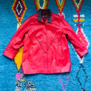 Röd läderjacka med lagning  - Röd läderjacka i toppenskick förutom en lagning i baseball-stitch vid fickan 