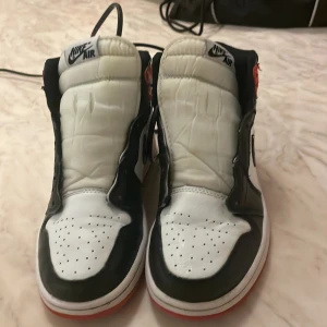 Nike Air Jordan 1 svart/vit/röd, 37 ss - Säljer ett par användna men i ganska bra skick. Nike Air Jordan 1 med klassisk färgkombination i svart, vitt och rött. Skorna har högt skaft.Jag har ingen skolåda så det kommer i något annat