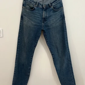 Blå wide jeans från Selected Homme - Snygga blå jeans från Selected Homme, modell Wide Kobe. Jeansen har en lite bredare passform och är tillverkade i ekologisk bomull. Klassisk femficksdesign och normal midja. Perfekta för dig som gillar en avslappnad och trendig look.